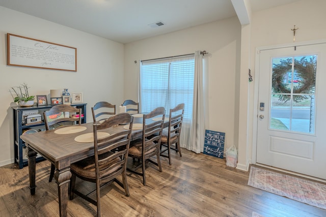 dining space featuring wood-type flooring and plenty of natural light