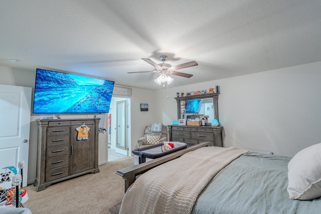 bedroom with ceiling fan, light colored carpet, and a textured ceiling