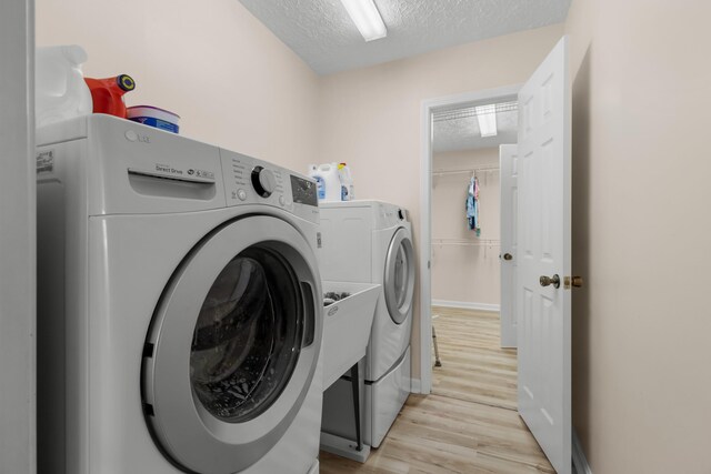 1114 Lake Ridge Dr, Dandridge, TN 37725 - laundry room featuring a textured ceiling, washer and dryer, light wood finished floors, and baseboards