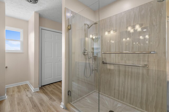 1114 Lake Ridge Dr, Dandridge, TN 37725 - full bathroom featuring a stall shower, wood finished floors, baseboards, and a textured ceiling