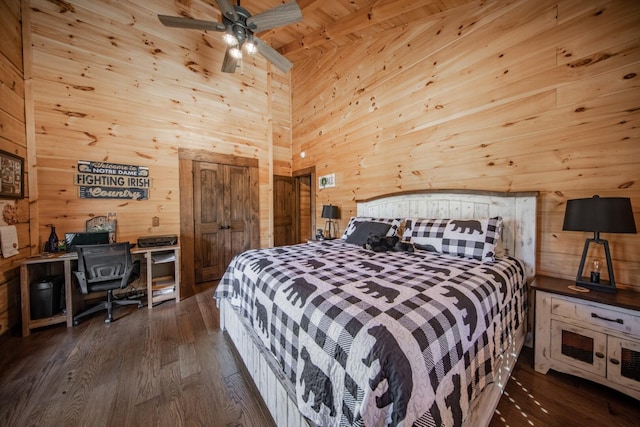 bedroom featuring dark hardwood / wood-style flooring, ceiling fan, wooden ceiling, a high ceiling, and wood walls