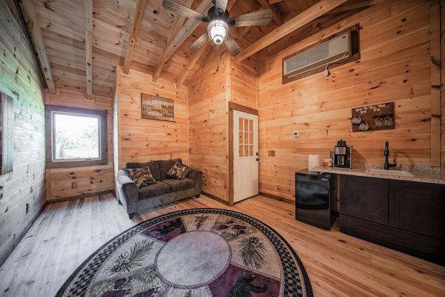 living area featuring lofted ceiling with beams, wooden ceiling, sink, and wooden walls