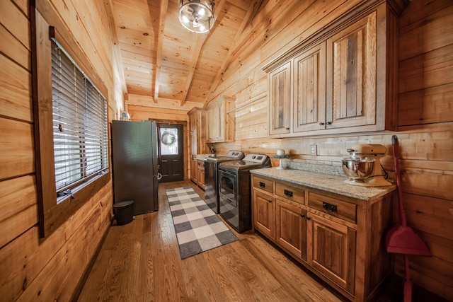 kitchen with wooden ceiling, vaulted ceiling with beams, stainless steel fridge, washing machine and dryer, and light wood-type flooring