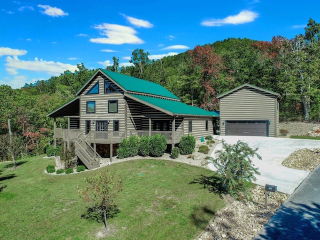 view of front of home with a garage, an outdoor structure, a wooden deck, and a front lawn