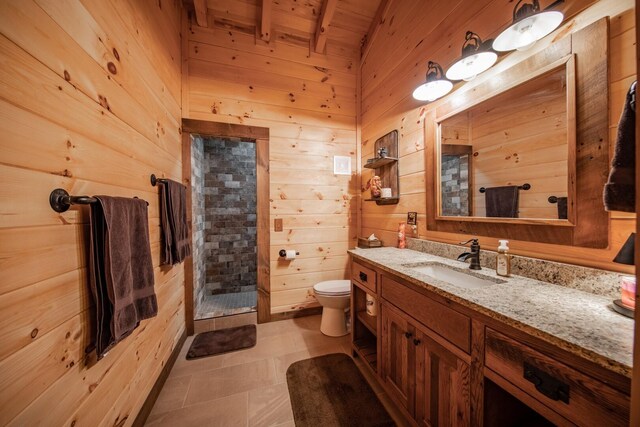 bathroom featuring vanity, a shower, beamed ceiling, toilet, and wood walls