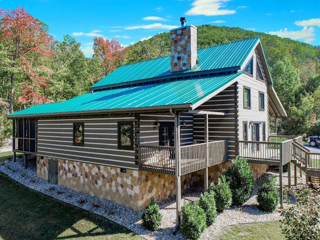 rear view of house featuring a wooden deck