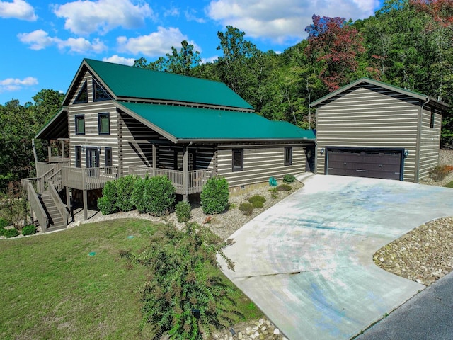 view of front facade with a front yard, a garage, and a deck