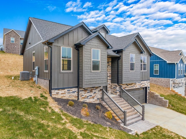 view of front facade featuring a front yard, a garage, and cooling unit