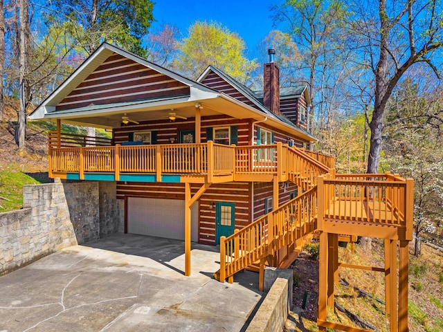 view of front of house with stairs, ceiling fan, a chimney, concrete driveway, and a deck