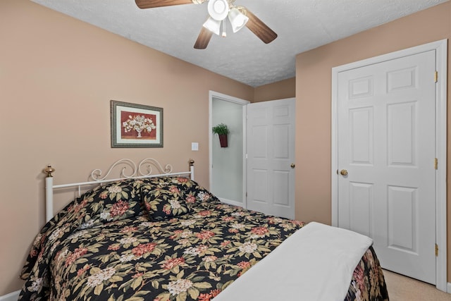 bedroom featuring light carpet, a ceiling fan, and a textured ceiling