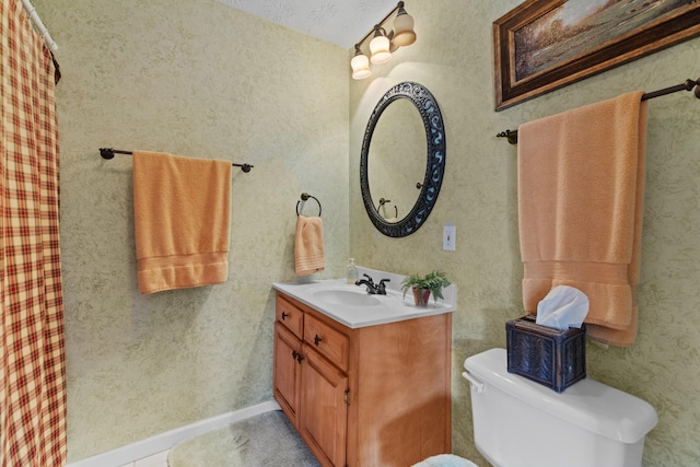 bathroom featuring toilet, vanity, and a shower with curtain