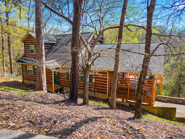 view of front of house featuring a deck and roof with shingles