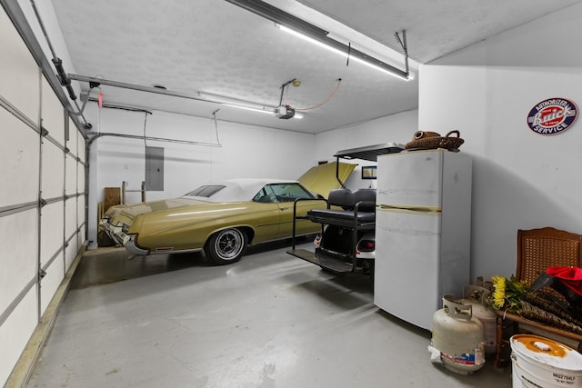 garage with freestanding refrigerator, a garage door opener, and electric panel