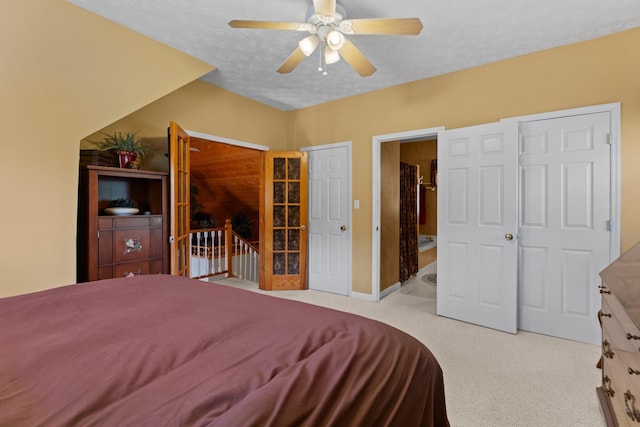 bedroom with light colored carpet, ceiling fan, baseboards, and a textured ceiling