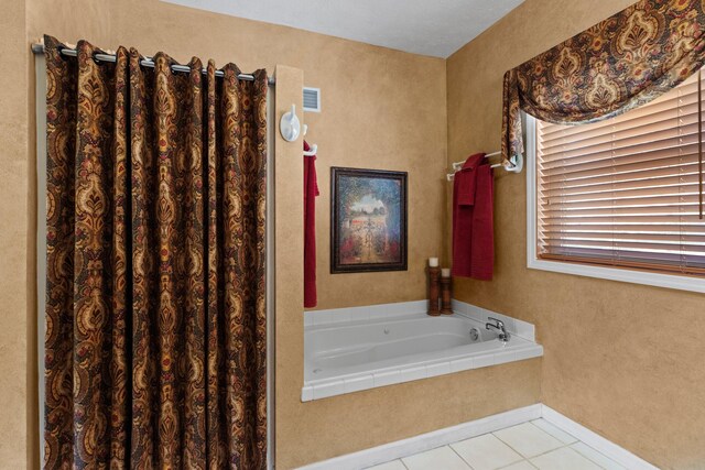 bathroom featuring baseboards, visible vents, a garden tub, and tile patterned flooring