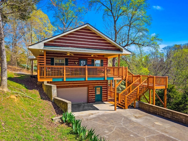 view of front facade featuring stairs, driveway, a deck, ceiling fan, and a garage