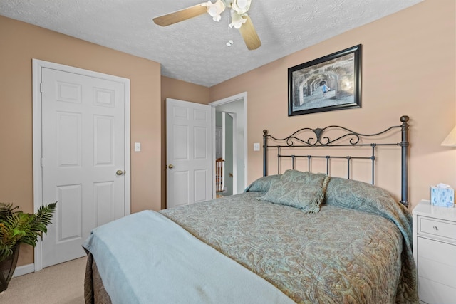 bedroom featuring light colored carpet, a ceiling fan, and a textured ceiling