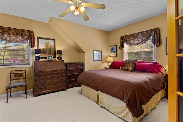 carpeted bedroom featuring baseboards, ceiling fan, and a textured ceiling
