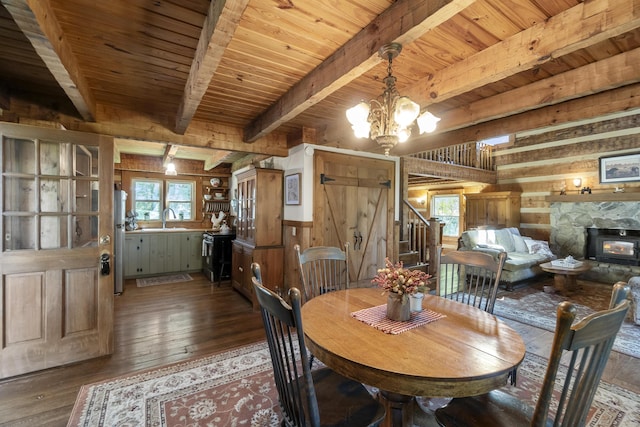 dining space featuring beam ceiling, wooden walls, a chandelier, and dark wood-type flooring