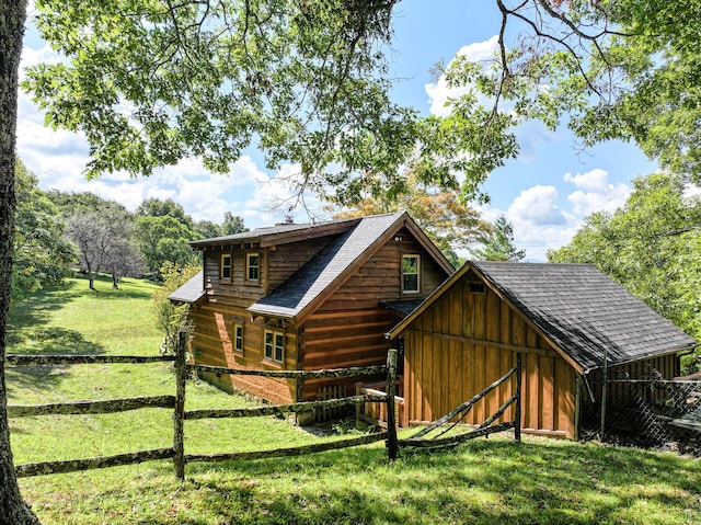 rear view of property featuring an outbuilding and a yard