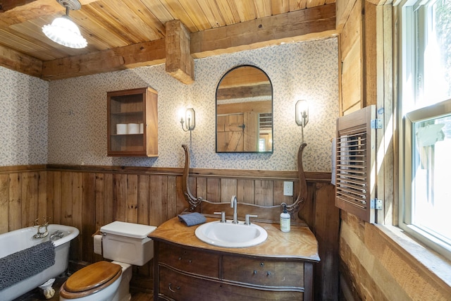 bathroom with vanity, wooden ceiling, a bathing tub, toilet, and beam ceiling