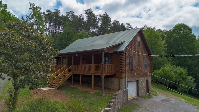 158 Delph Ln, Mooresburg, TN 37811 - view of front of house featuring dirt driveway, log exterior, an attached garage, covered porch, and a metal roof