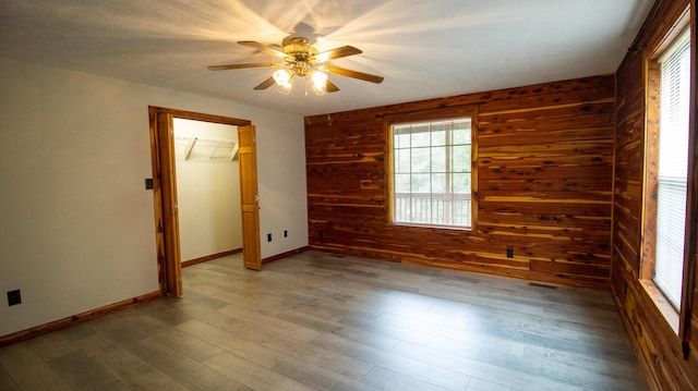 158 Delph Ln, Mooresburg, TN 37811 - unfurnished bedroom featuring wood walls, light wood-style flooring, a closet, and ceiling fan
