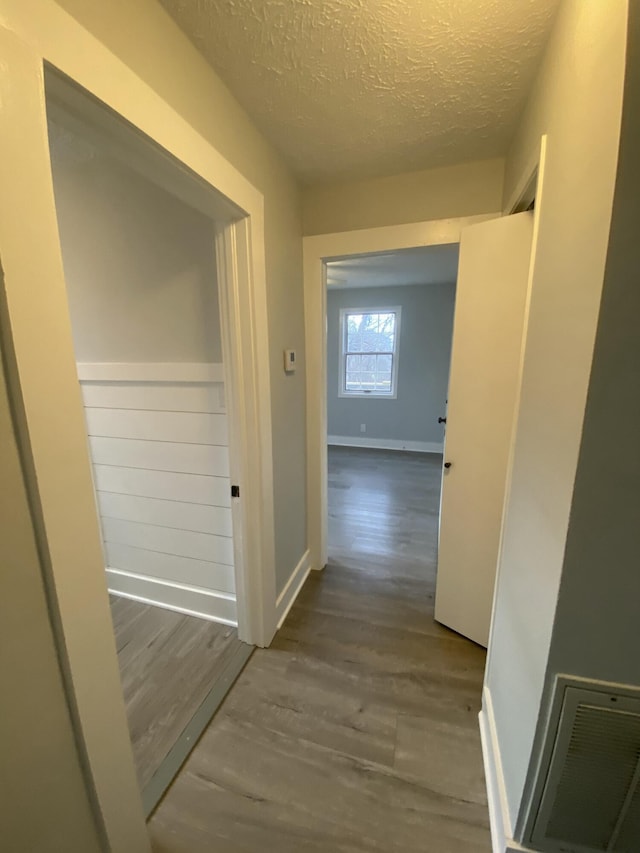 hallway featuring hardwood / wood-style flooring and a textured ceiling