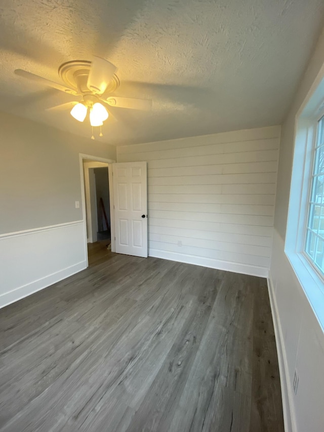 empty room featuring a textured ceiling and dark wood-type flooring