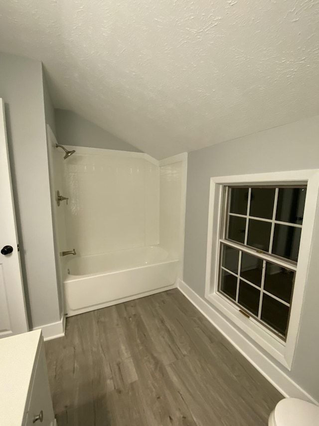 bathroom with toilet, a textured ceiling, lofted ceiling, hardwood / wood-style floors, and vanity