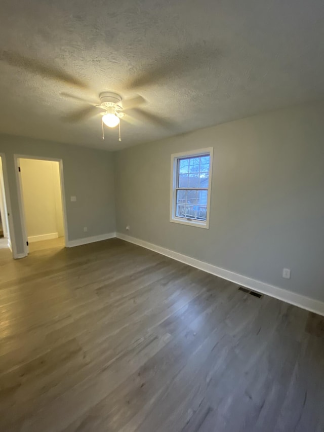 unfurnished bedroom with dark hardwood / wood-style flooring, ceiling fan, and a textured ceiling