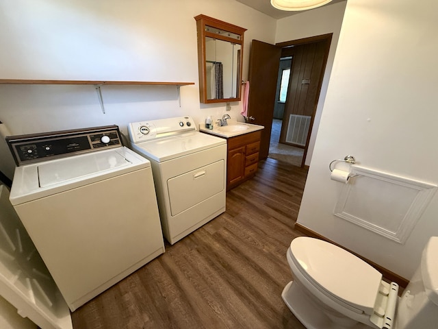 laundry area featuring dark hardwood / wood-style flooring, independent washer and dryer, and sink