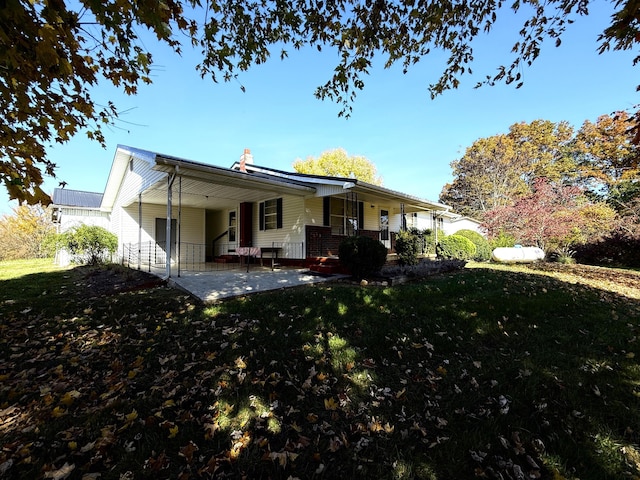 rear view of house featuring a lawn and a patio area