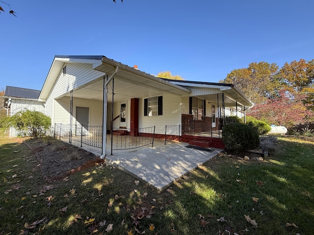 back of property featuring a porch and a yard