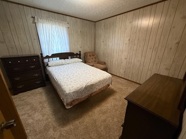 carpeted bedroom featuring a textured ceiling and wood walls