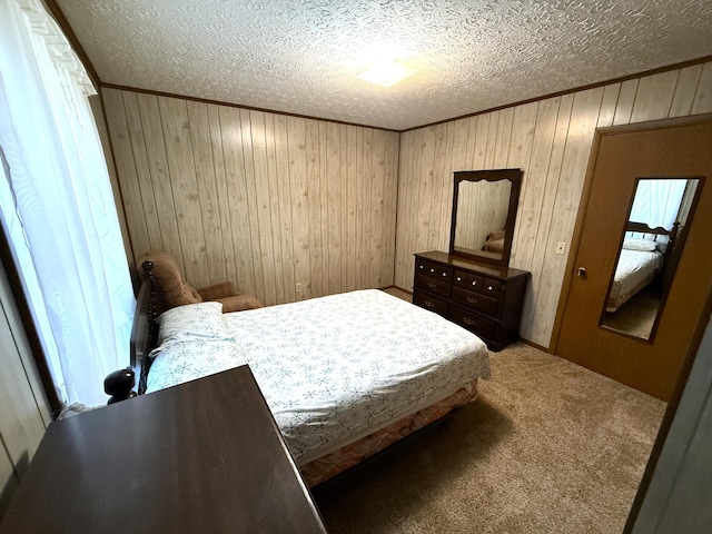 bedroom featuring carpet flooring, a textured ceiling, and wooden walls