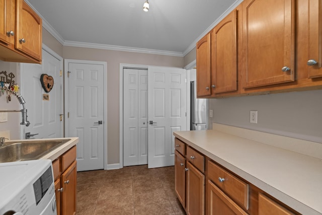 117 Tahlequah Ln, Loudon, TN 37774 - kitchen featuring washer / dryer, freestanding refrigerator, light countertops, ornamental molding, and brown cabinets