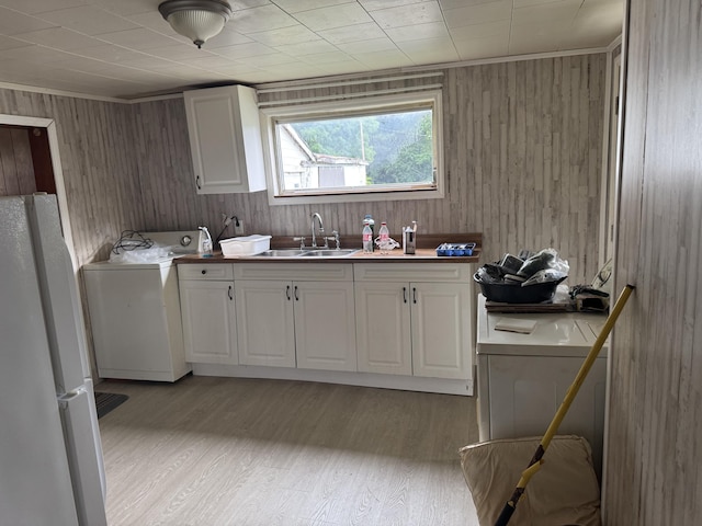 166 Clevenger Cut Off Rd, Newport, TN 37821 - laundry area with washer / clothes dryer, cabinet space, wood walls, and light wood-style floors