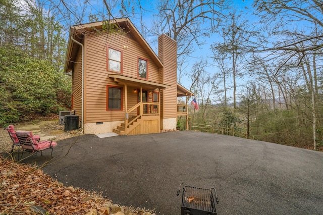 chalet / cabin featuring crawl space, central air condition unit, and a chimney