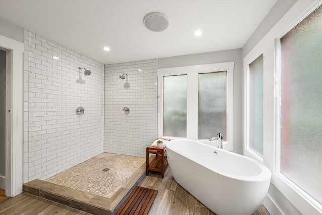 bathroom featuring a soaking tub, recessed lighting, tiled shower, and wood finished floors