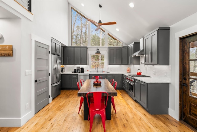 kitchen featuring ceiling fan, stainless steel appliances, a sink, and decorative backsplash