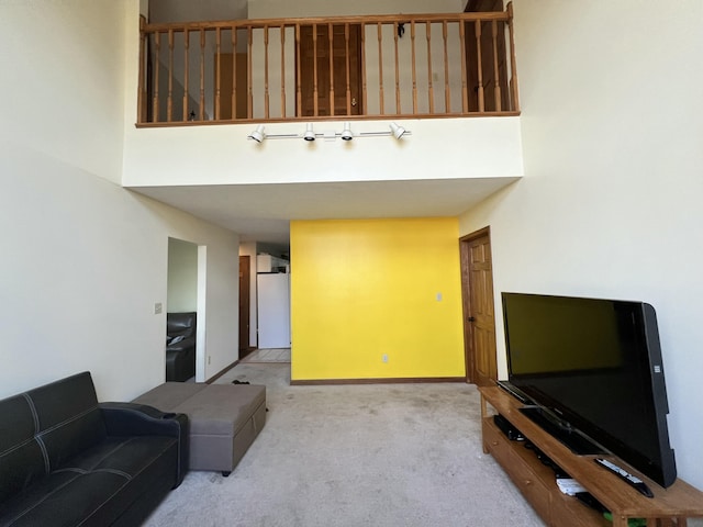 living room with light colored carpet and a towering ceiling