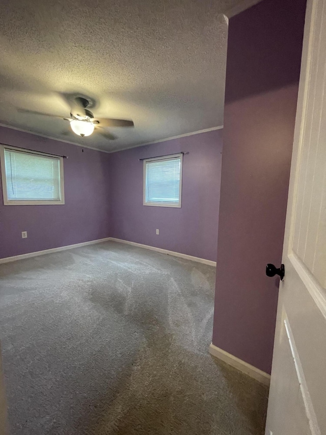 carpeted empty room featuring ceiling fan and a textured ceiling