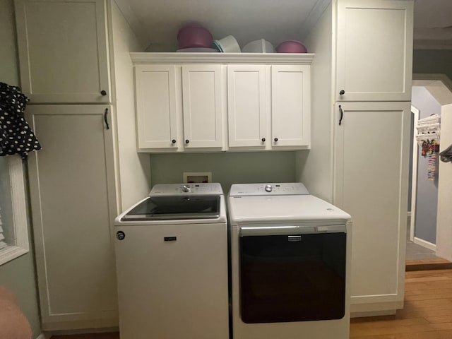 washroom with cabinets, independent washer and dryer, light wood-type flooring, and ornamental molding