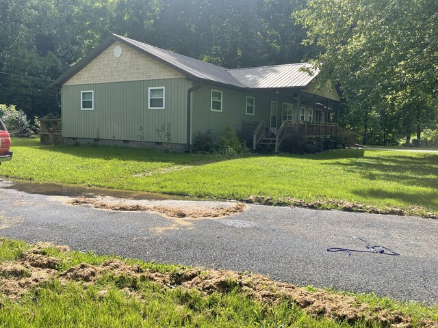 view of property exterior with covered porch and a yard