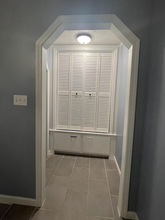 corridor with dark tile patterned flooring