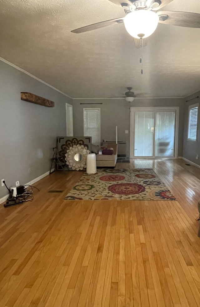 unfurnished room with hardwood / wood-style floors, a textured ceiling, and crown molding