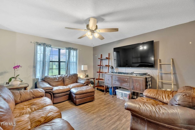 living area with light wood-style flooring, a textured ceiling, and a ceiling fan
