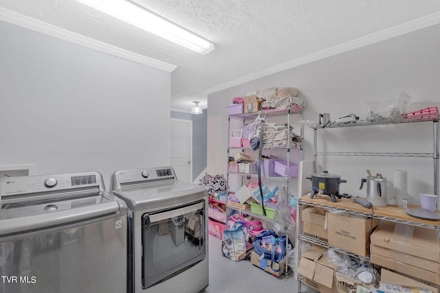laundry area featuring washing machine and dryer, a textured ceiling, and ornamental molding