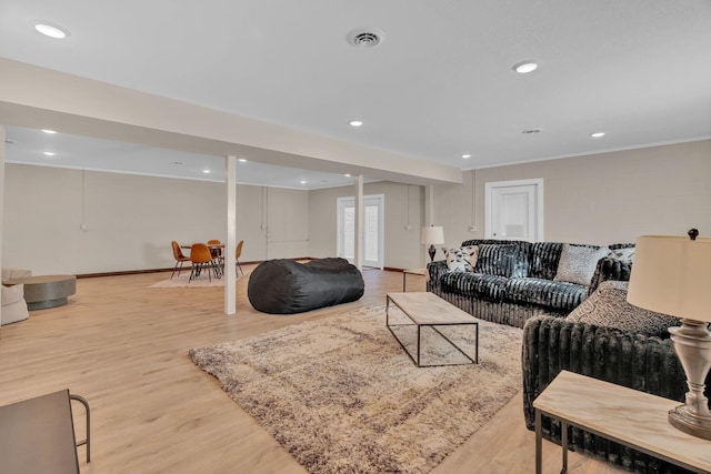 living room featuring baseboards, visible vents, wood finished floors, and recessed lighting